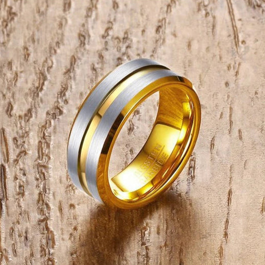 Two-tone gold and silver ring on a wooden surface